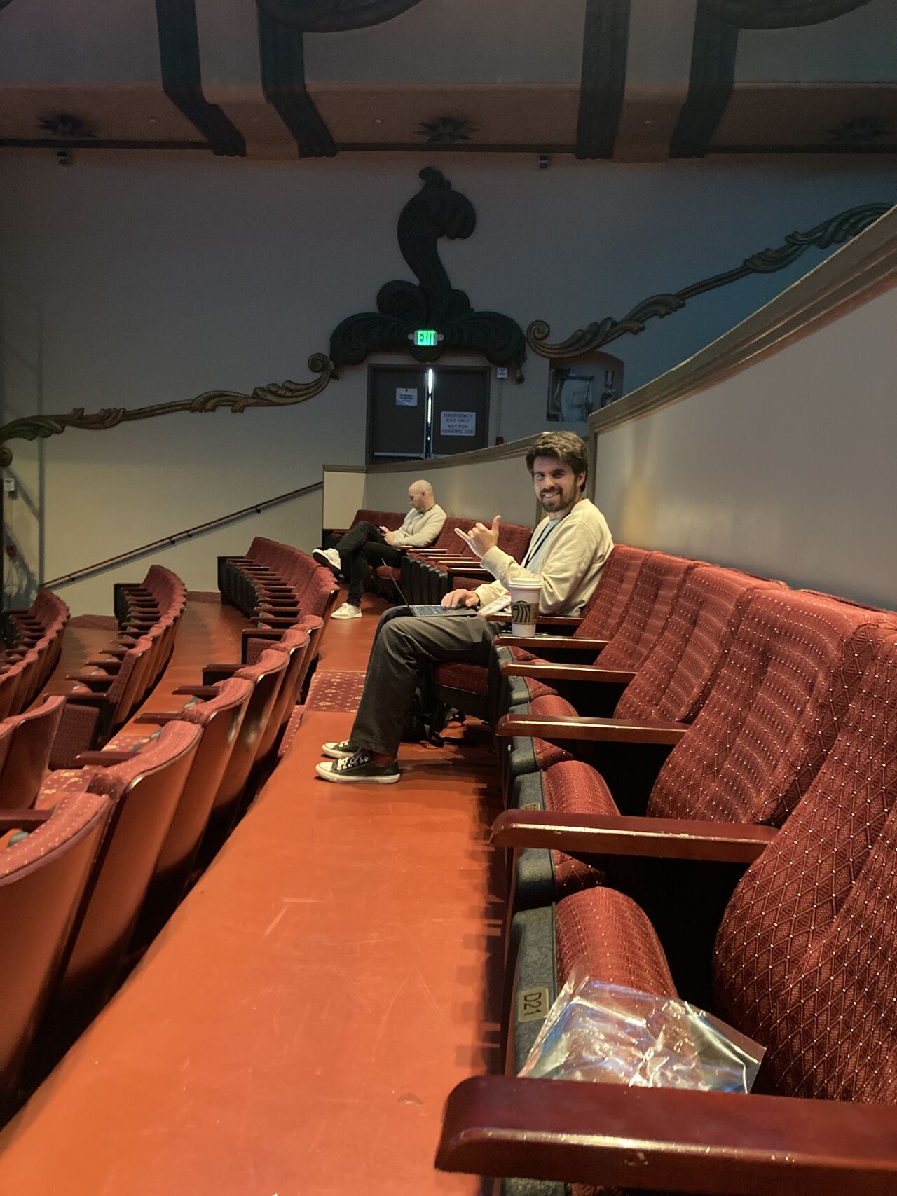 Working from an ornate theater balcony with laptop and coffee